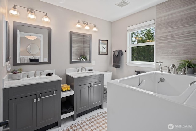 full bathroom with a freestanding bath, two vanities, and tile patterned floors
