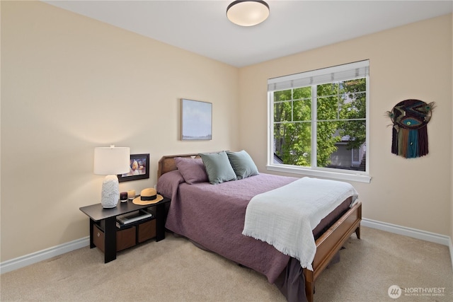 bedroom with baseboards and light colored carpet
