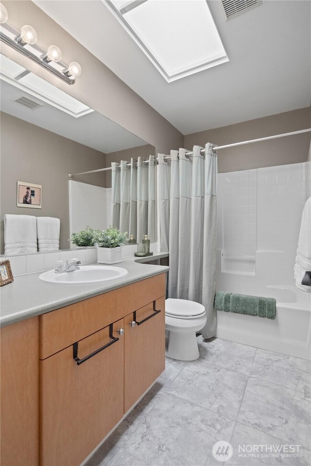 bathroom with toilet, vanity, shower / bathtub combination with curtain, and a skylight