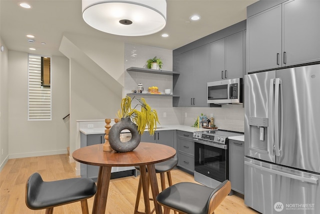 1106B 34th Ave, Seattle, WA 98122 - kitchen featuring stainless steel appliances, gray cabinetry, light countertops, open shelves, and light wood-style flooring