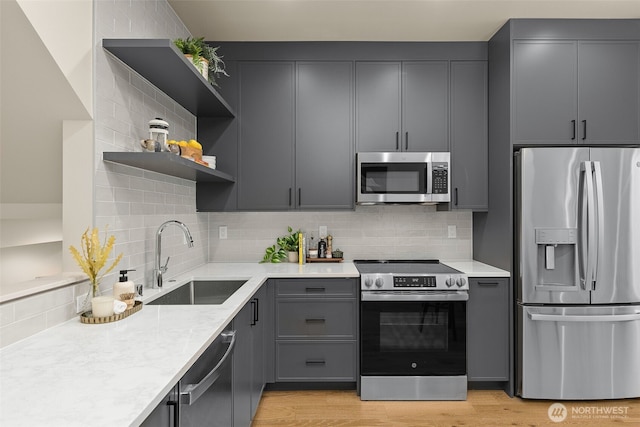 1106B 34th Ave, Seattle, WA 98122 - kitchen with stainless steel appliances, a sink, decorative backsplash, open shelves, and light stone counters