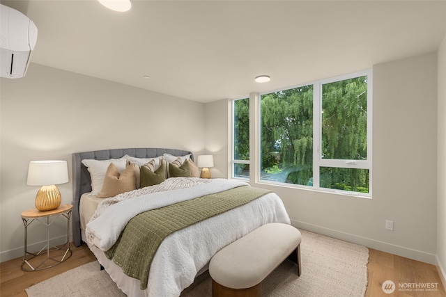 1106B 34th Ave, Seattle, WA 98122 - bedroom with an AC wall unit, baseboards, and wood finished floors