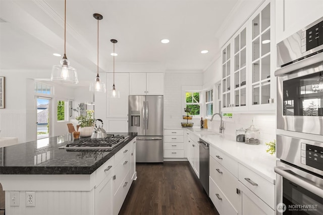 7934 Lake View Ln, Mercer Island, WA 98040 - kitchen featuring appliances with stainless steel finishes, ornamental molding, white cabinets, a sink, and glass insert cabinets