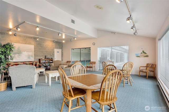 dining area with track lighting, carpet, a baseboard heating unit, and lofted ceiling