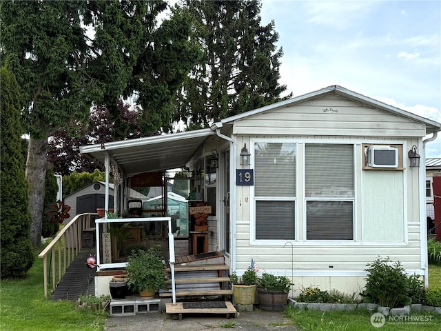 manufactured / mobile home featuring a shed and an outdoor structure
