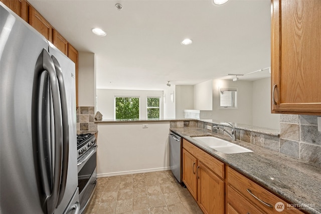 430 SW 156th St Unit 204, Burien, WA 98166 - kitchen with appliances with stainless steel finishes, a sink, backsplash, brown cabinetry, and dark stone counters