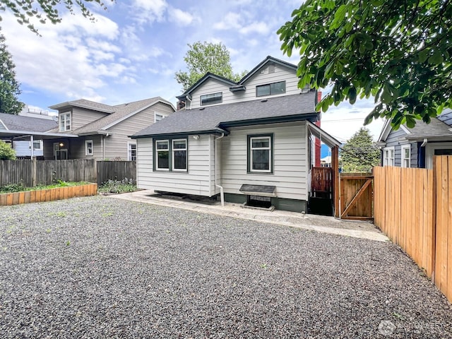 1915 Dexter Ave N, Seattle, WA 98109 - back of property featuring a fenced backyard, roof with shingles, and a gate