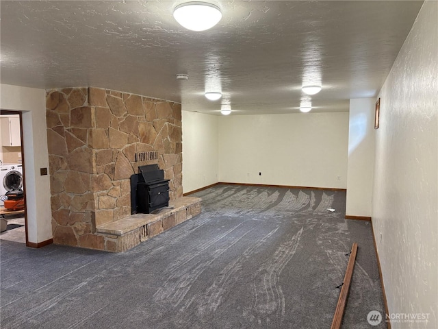 54 Jaquish Rd, Omak, WA 98841 - finished basement featuring a wood stove, carpet flooring, baseboards, a textured ceiling, and washer / dryer