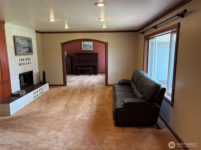 54 Jaquish Rd, Omak, WA 98841 - living room with light colored carpet, arched walkways, a fireplace, baseboards, and crown molding