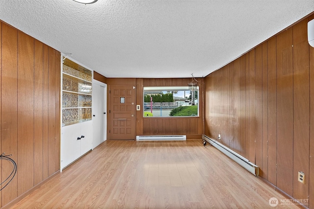 1811 S Sprague Ave, Tacoma, WA 98405 - spare room featuring wood finished floors, baseboard heating, a textured ceiling, and wooden walls