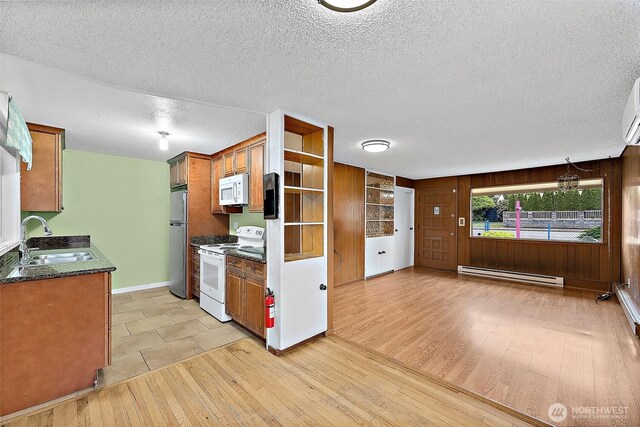 1811 S Sprague Ave, Tacoma, WA 98405 - kitchen with white appliances, a sink, baseboard heating, light wood finished floors, and brown cabinets