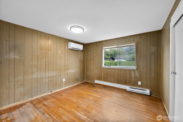 1811 S Sprague Ave, Tacoma, WA 98405 - empty room with a wall mounted air conditioner, baseboard heating, hardwood / wood-style floors, a textured ceiling, and wooden walls