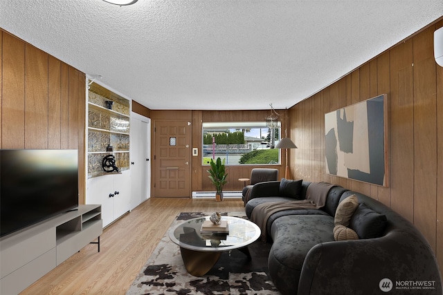 1811 S Sprague Ave, Tacoma, WA 98405 - living room with wood walls, light wood-style flooring, a textured ceiling, and baseboard heating