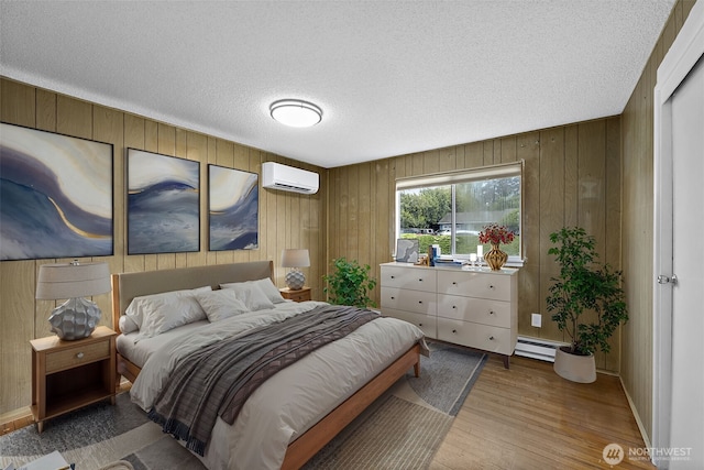 1811 S Sprague Ave, Tacoma, WA 98405 - bedroom featuring a wall mounted air conditioner, a textured ceiling, wood finished floors, wooden walls, and baseboard heating