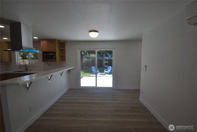 64 Queets St, Steilacoom, WA 98388 - kitchen featuring stainless steel microwave, island range hood, a wall mounted air conditioner, a kitchen bar, and a sink