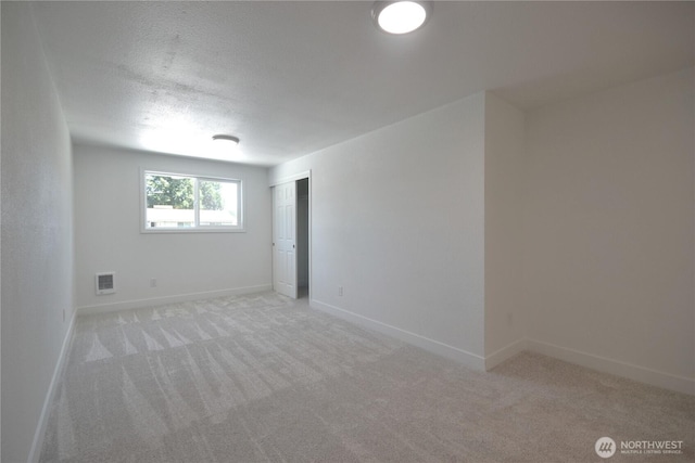 64 Queets St, Steilacoom, WA 98388 - spare room with light colored carpet, baseboards, and a textured ceiling