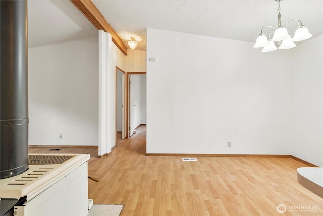 unfurnished dining area with light wood-style floors, a chandelier, and baseboards