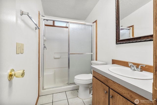 bathroom with tile patterned flooring, toilet, a stall shower, vanity, and a textured ceiling