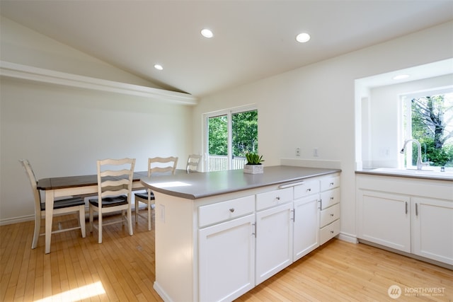 kitchen featuring a sink, light wood-style flooring, a peninsula, healthy amount of natural light, and recessed lighting