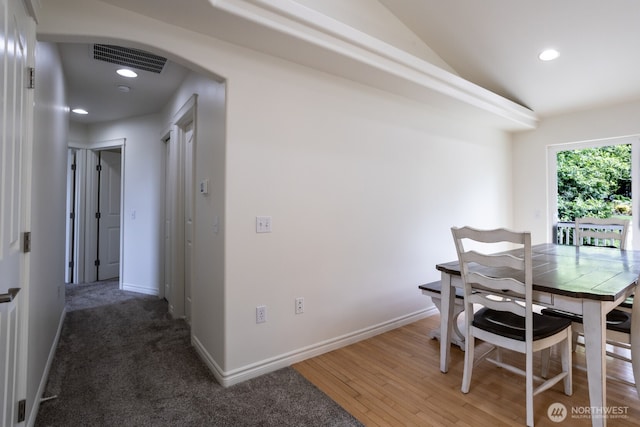dining area with arched walkways, recessed lighting, vaulted ceiling, baseboards, and wood finished floors
