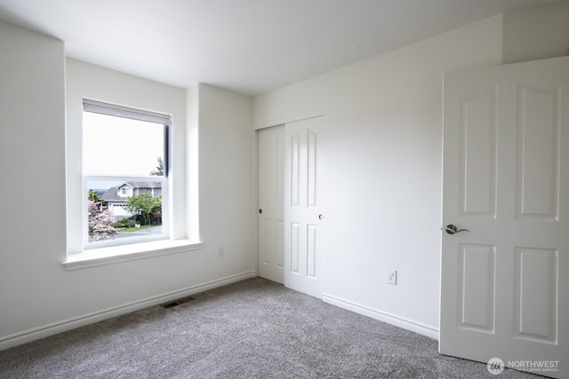 unfurnished bedroom featuring carpet flooring, a closet, and baseboards
