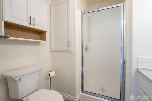 bathroom featuring a stall shower, toilet, and vanity