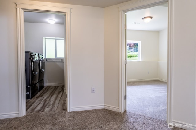 clothes washing area featuring independent washer and dryer, carpet, and baseboards