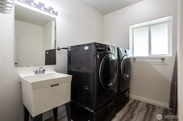 laundry area featuring washing machine and dryer, wood finished floors, and baseboards