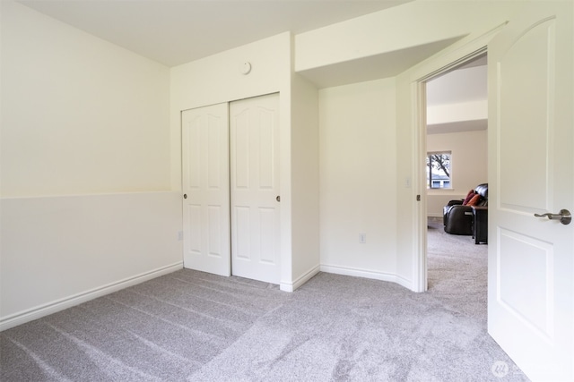 unfurnished bedroom with carpet floors, a closet, and baseboards