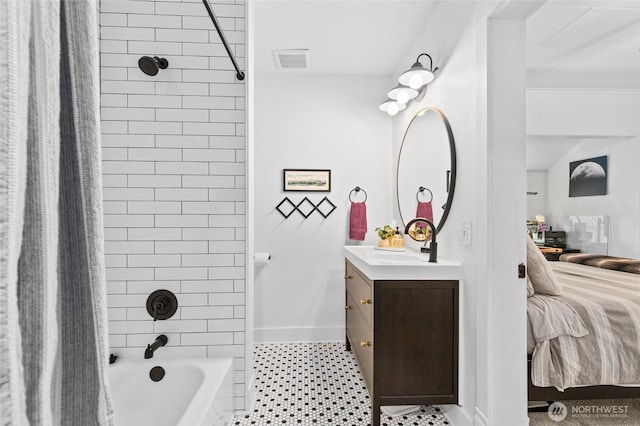 bathroom featuring ensuite bath, vanity, shower / bath combo with shower curtain, and baseboards