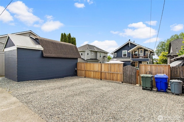view of yard featuring fence, a gate, a residential view, and an outdoor structure