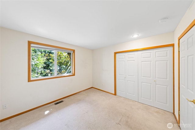 unfurnished bedroom featuring carpet flooring, baseboards, and a closet