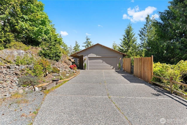 view of front of house featuring fence, concrete driveway, and a garage