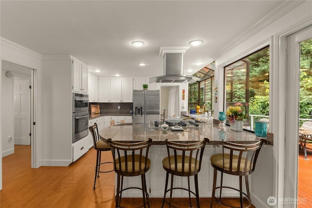 21842 NE 30th Pl, Sammamish, WA 98074 - kitchen featuring stainless steel appliances, a peninsula, decorative backsplash, white cabinetry, and light wood-style flooring