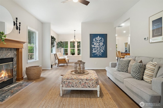 13212 Wicks End Ln SW, Port Orchard, WA 98367 - living area with wood finished floors, plenty of natural light, a ceiling fan, and a high end fireplace