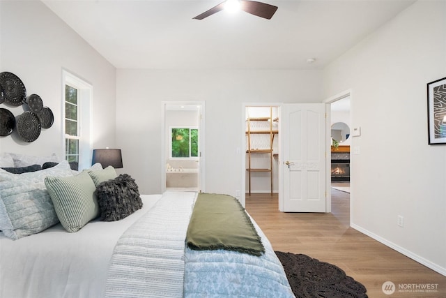 13212 Wicks End Ln SW, Port Orchard, WA 98367 - bedroom with wood finished floors, a spacious closet, ensuite bathroom, a ceiling fan, and baseboards