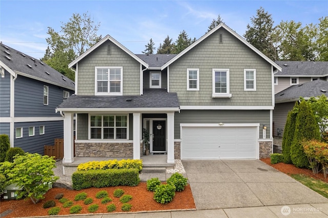 craftsman-style house with stone siding, concrete driveway, and an attached garage