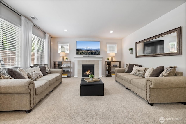 carpeted living area with a tile fireplace and recessed lighting