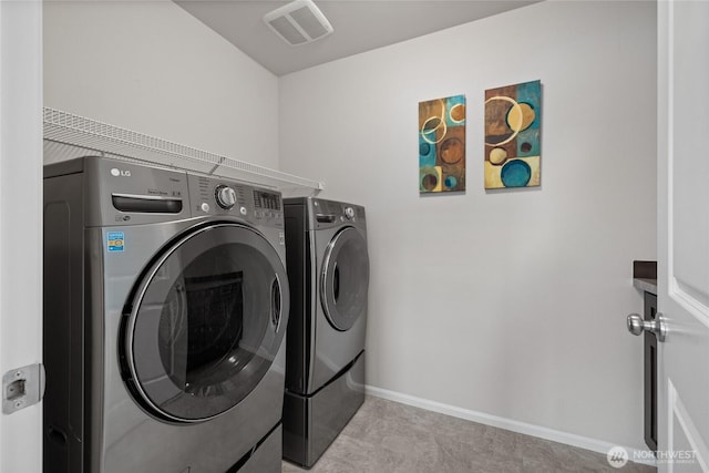 laundry room with washer and clothes dryer and baseboards