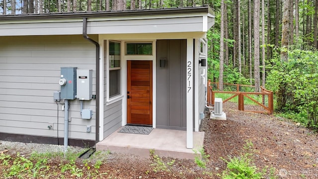 22717 Briarwood Ct SE, Yelm, WA 98597 - doorway to property with fence, board and batten siding, and a view of trees