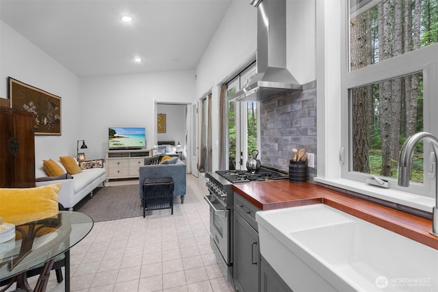 22717 Briarwood Ct SE, Yelm, WA 98597 - kitchen featuring high end stainless steel range oven, a sink, wall chimney exhaust hood, wood counters, and recessed lighting