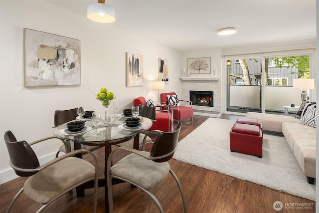 living area featuring a warm lit fireplace and wood finished floors