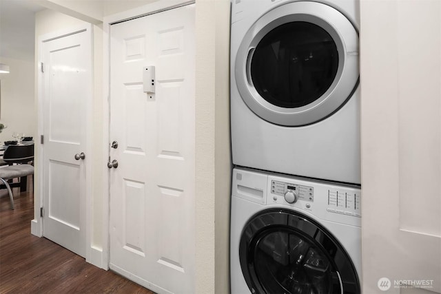 laundry area with stacked washer / dryer and dark wood-style floors