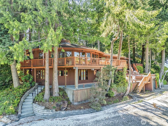 1678 NE Jacobson Rd, Poulsbo, WA 98370 - back of property featuring a deck, stairs, and a chimney
