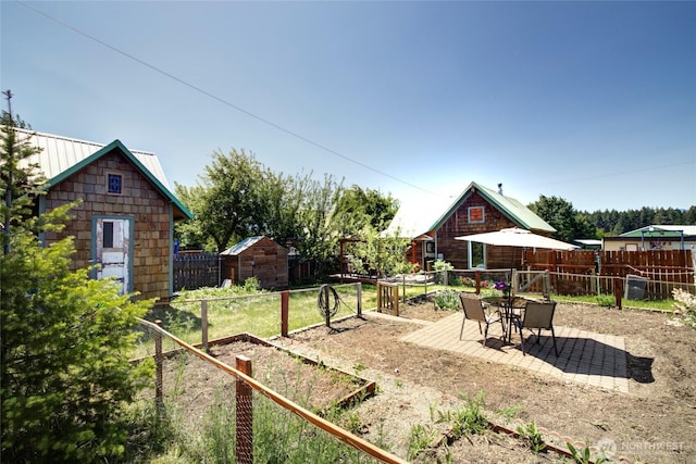 531 3rd St, Ronald, WA 98940 - fenced backyard with a vegetable garden, a shed, an outdoor structure, and a patio area
