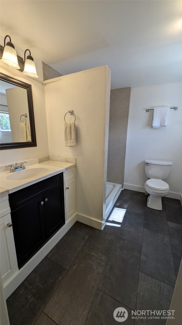 531 3rd St, Ronald, WA 98940 - bathroom with toilet, vanity, baseboards, a tile shower, and tile patterned flooring