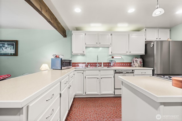 27428 97th Ave SW, Vashon, WA 98070 - kitchen featuring appliances with stainless steel finishes, a sink, a peninsula, light countertops, and white cabinetry