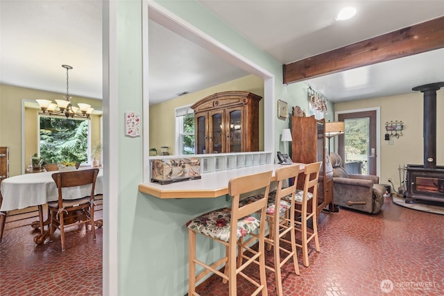 27428 97th Ave SW, Vashon, WA 98070 - kitchen featuring a wood stove, a chandelier, and beamed ceiling