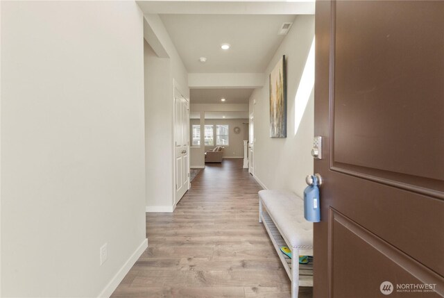 corridor featuring light wood-style floors, recessed lighting, and baseboards