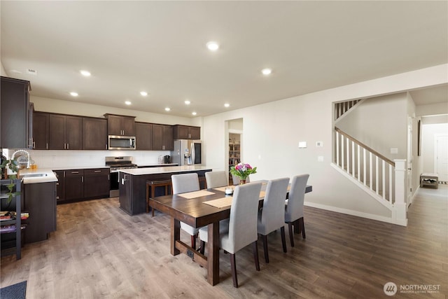 dining space featuring stairs, wood finished floors, recessed lighting, and baseboards
